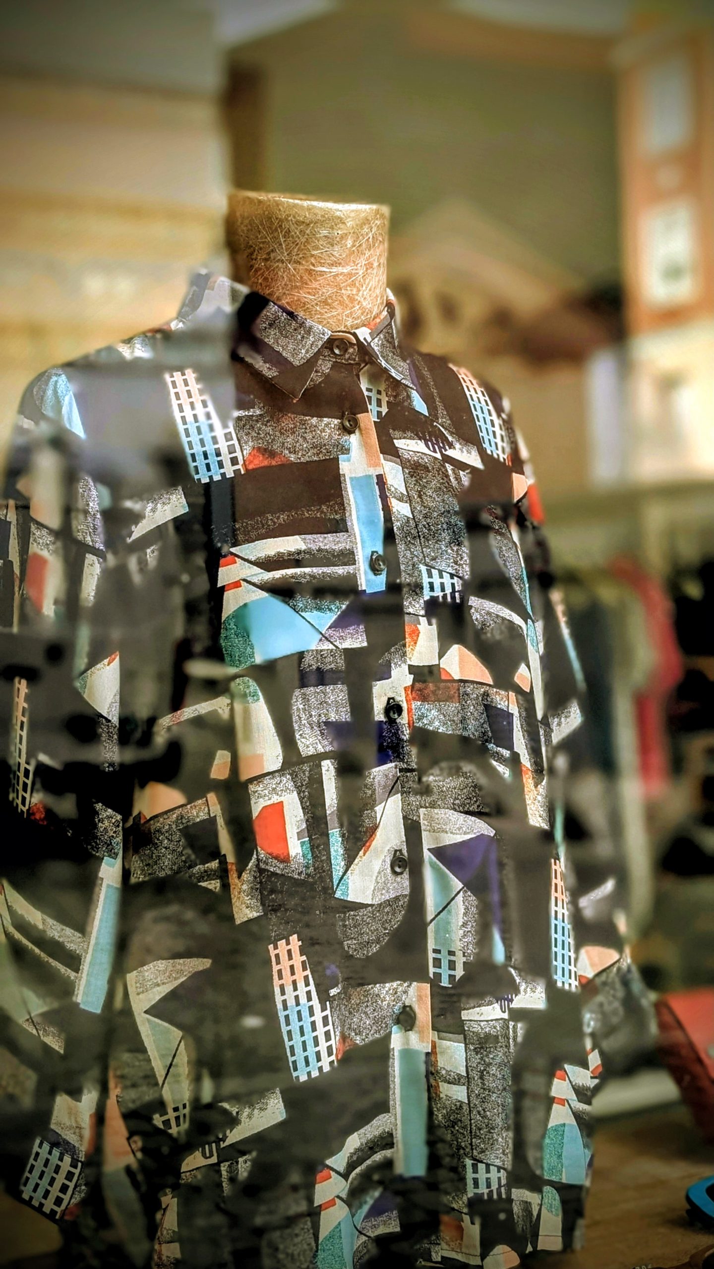 Camisa de Miseria en el escaparate, con reflejos de la calle